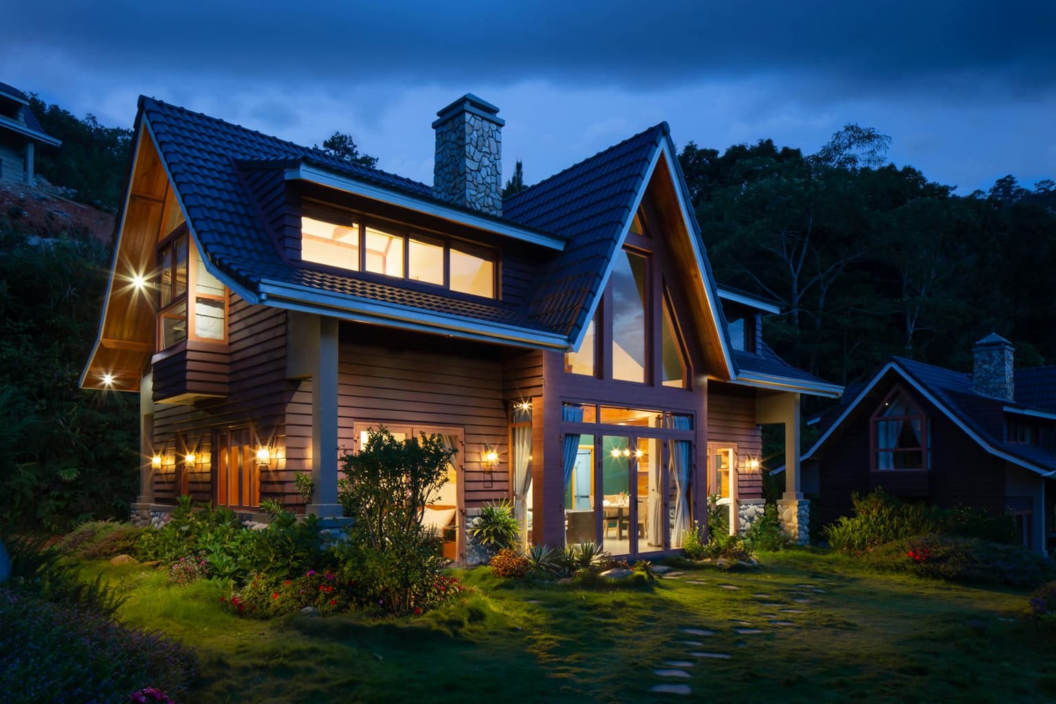 Wooden family home with warm lights glowing at dusk
